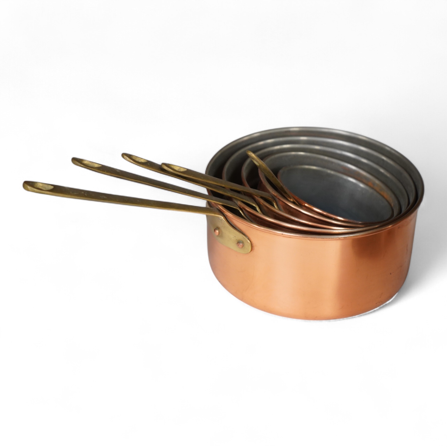 A graduated set of five brass handled copper saucepans, largest 36cm including handle.